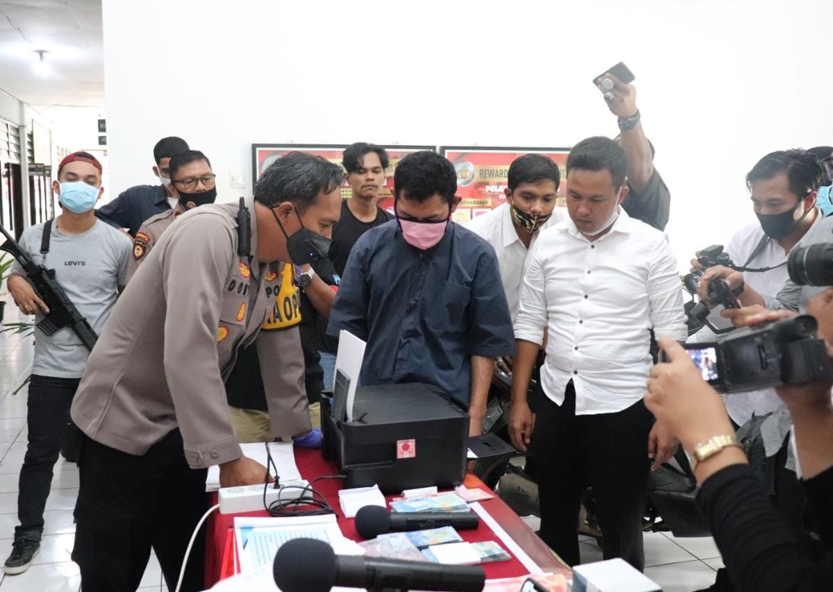 Tersangka Memperagakan Cara Membuat Uang Palsu