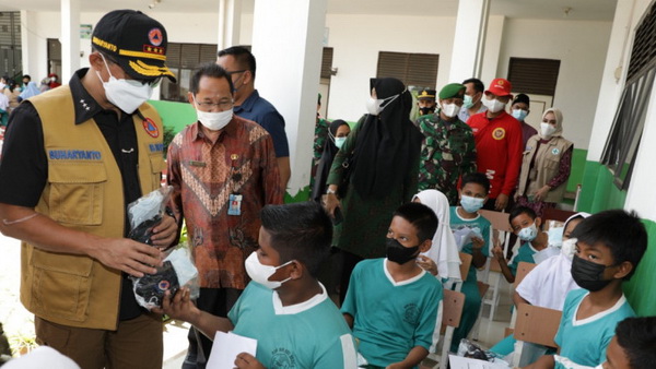 Kepala Bnpb Sekaligus Ketua Satgas Penanganan Covid-19 Letjen Tni Suharyanto (Kiri) Memberikan Masker Gratis Kepada Seorang Siswa Yang Telah Menerima Vaksin Covid-19 Di Sd 006 Sei Beduk, Kota Batam