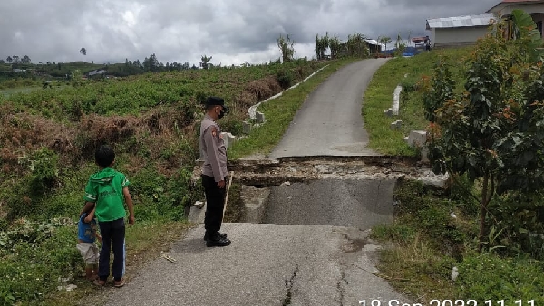 Polisi Memperhatikan Jembatanyang Amblas