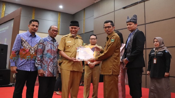 Gubernur Sumbar, Mahyeldi didampingi Wakil Ketua KI Pusat Arya Sandhiyudha dan Ketua KI Sumbar Nofal Wiska serahkan penghargaan pada Rafllis