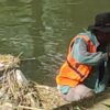 Salah seorang petugas kebersihan yang langsung membuang potongan rumput ke aliran Batang Jirak di Kelurahan Pampangan Nan XX, Senin (24/7/2023) sore.