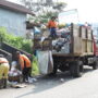 Pekerja Kebersihan Pada Truk Sampah Sedang Mengambil Sampah Di Tepi Jalan Raya Untuk Dibuang Ke Tpa Sampah Sungai Andok.